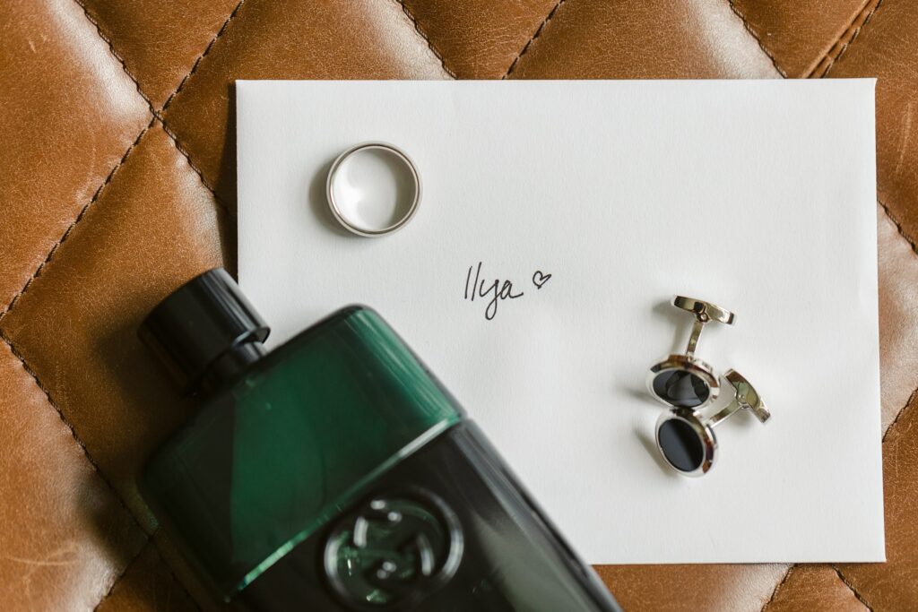 Groom detail photography of cufflinks and cologne 
